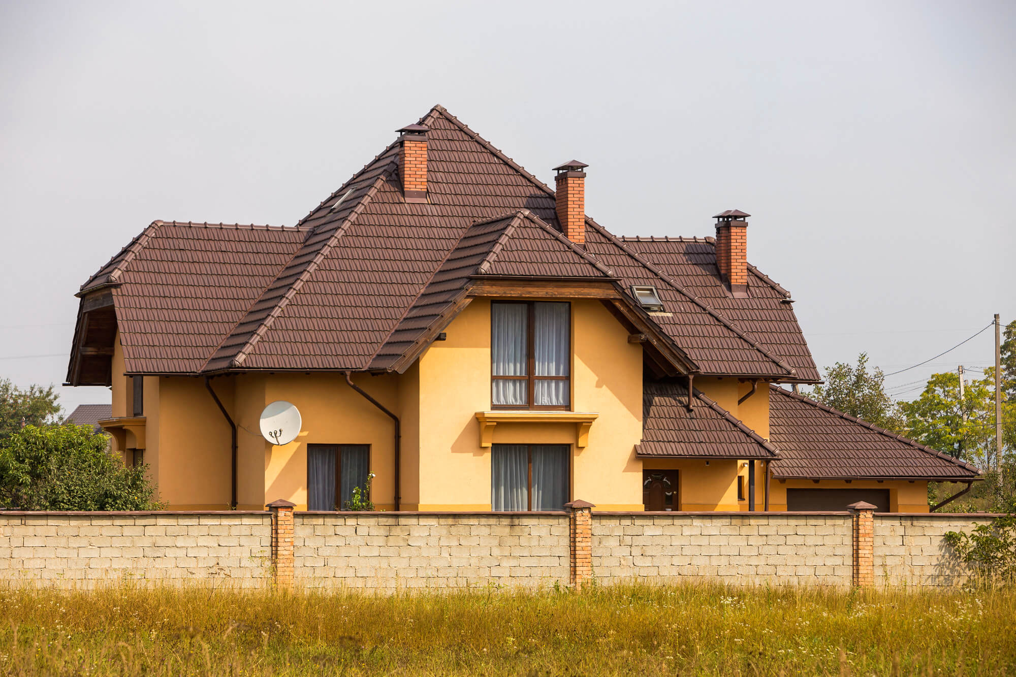 new-comfortable-two-storied-cottage-with-steep-shingle-roof-satellite-dish-stucco-wall